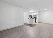 Thumbnail 14 of 38 - A spacious room with a kitchen area in the background.