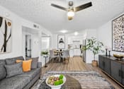 Thumbnail 5 of 26 - A living room with a grey couch and a ceiling fan.