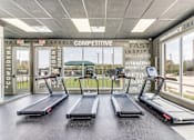 Thumbnail 21 of 34 - Three treadmills are lined up in a row in a gym.