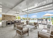 Thumbnail 27 of 34 - A patio with a white ceiling and furniture.
