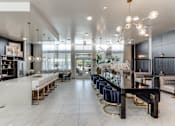 Thumbnail 24 of 34 - A modern kitchen with a long white island and bar stools.