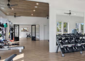 Thumbnail 27 of 47 - A gym with a variety of equipment including a rowing machine.