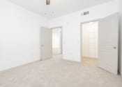 Thumbnail 41 of 41 - a bedroom with white walls and white doors and a carpeted floor