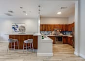 Thumbnail 19 of 30 - A kitchen with a bar area and two stools.