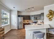 Thumbnail 1 of 30 - A kitchen with a white island and a refrigerator.