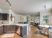 Thumbnail 2 of 30 - A modern kitchen with dark wood cabinets and a white island.