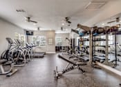 Thumbnail 23 of 30 - A spacious gym with treadmills, elliptical machines, and weightlifting equipment.