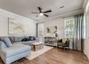 Thumbnail 5 of 30 - A living room with a grey couch, a green armchair, and a wooden coffee table.