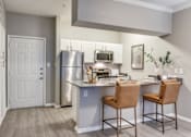 Thumbnail 8 of 37 - an open kitchen with stainless steel appliances and a counter with two chairs