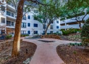 Thumbnail 37 of 37 - an outdoor courtyard with trees and a path in front of an apartment building
