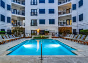Thumbnail 26 of 37 - an apartment swimming pool in front of an apartment building