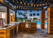 Thumbnail 30 of 37 - a kitchen with a sink and a stove in a backyard with a pool