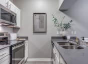 Thumbnail 10 of 37 - an empty kitchen with stainless steel appliances and a sink