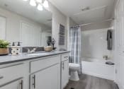 Thumbnail 17 of 37 - a bathroom with white cabinets and a white toilet and a tub