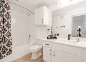 Thumbnail 38 of 41 - a bathroom with a white sink and toilet and a shower