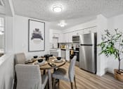 Thumbnail 2 of 26 - A modern kitchen with a dining table set for four.
