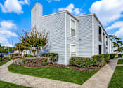 Thumbnail 25 of 27 - an apartment building with blue siding and a sidewalk and green grass