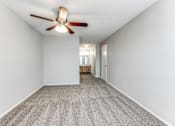 Thumbnail 20 of 27 - a spacious living room with white walls and a ceiling fan