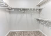 Thumbnail 17 of 27 - a walk in closet with white hooks and a shelf on the wall