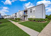 Thumbnail 27 of 27 - A modern building with a grey facade and a green lawn in front.