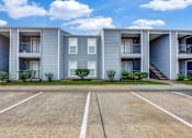 Thumbnail 26 of 27 - A row of grey apartment buildings with a clear blue sky above.