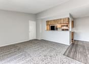 Thumbnail 18 of 27 - an empty living room with a kitchen in the corner