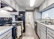 Thumbnail 14 of 27 - a kitchen with white cabinets and black appliances and a sink