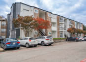 Thumbnail 33 of 33 - an apartment building with cars parked in front of it