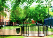 Thumbnail 25 of 30 - A black fence surrounds a green park area.