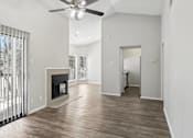 Thumbnail 5 of 24 - A spacious living room with a fireplace and a ceiling fan.