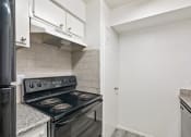 Thumbnail 20 of 34 - an empty kitchen with a stove and a refrigerator
