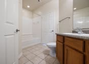 Thumbnail 10 of 30 - A white bathroom with a toilet, sink, and mirror.