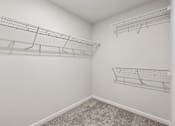 Thumbnail 49 of 56 - A white wall with three empty wire shelves.