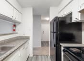 Thumbnail 5 of 34 - a kitchen with white cabinets and a black refrigerator