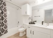 Thumbnail 17 of 41 - a white bathroom with a shower and a toilet and a sink