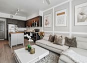Thumbnail 4 of 34 - A modern living room with a grey sofa and a white coffee table.