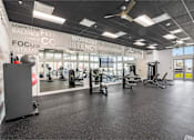 Thumbnail 10 of 31 - A gym with a variety of equipment including treadmills, weights, and exercise machines.