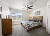 Thumbnail 36 of 41 - a bedroom with a bed and a ceiling fan