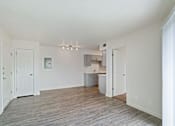 Thumbnail 7 of 19 - an empty living room and kitchen with a wood floor