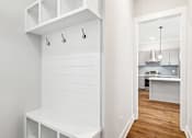Thumbnail 30 of 38 - A white kitchen with a white bench and a white cabinet.