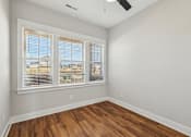Thumbnail 19 of 38 - A room with wooden floors and a window with blinds.