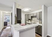 Thumbnail 20 of 31 - A kitchen with a white counter top and a sink.