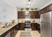 Thumbnail 11 of 38 - A modern kitchen with dark brown cabinets and stainless steel appliances.