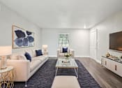 Thumbnail 6 of 17 - A living room with a white sofa, a coffee table, and a painting on the wall.