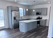 Thumbnail 28 of 32 - A kitchen with a large island and stainless steel appliances.