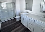Thumbnail 31 of 32 - A bathroom with a white toilet, sink, and mirror.
