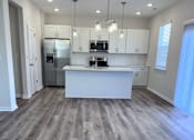 Thumbnail 29 of 32 - A kitchen with a white counter and a refrigerator.