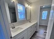 Thumbnail 27 of 32 - A bathroom with a sink, mirror, and lighting fixtures.