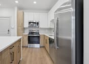 Thumbnail 21 of 33 - A modern kitchen with a refrigerator on the right.