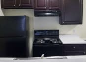 Thumbnail 1 of 8 - a kitchen with a stove and a refrigerator